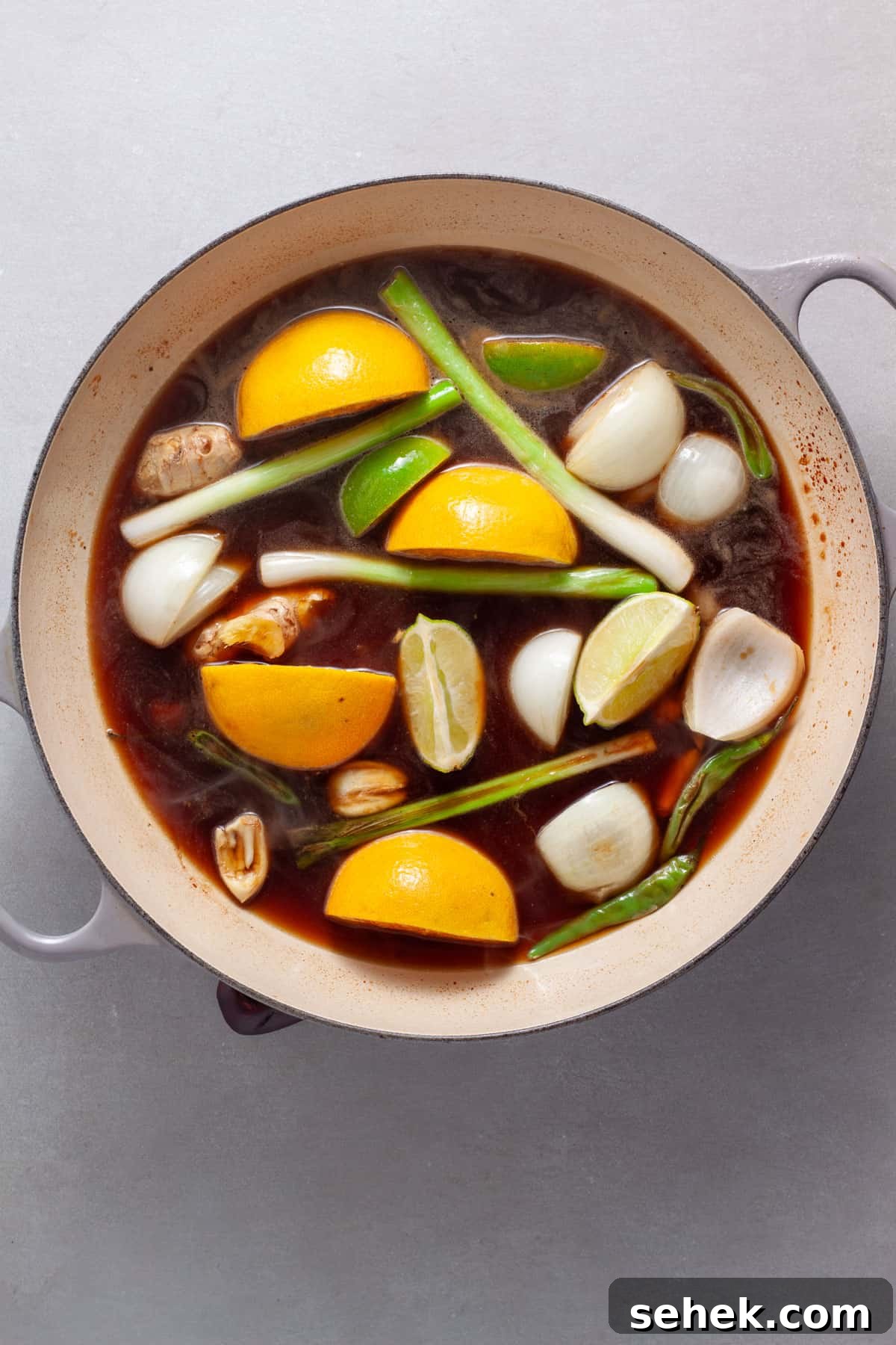 Sauce for a spicy chicken with citrus, ginger and soy getting prepared in a large skillet.