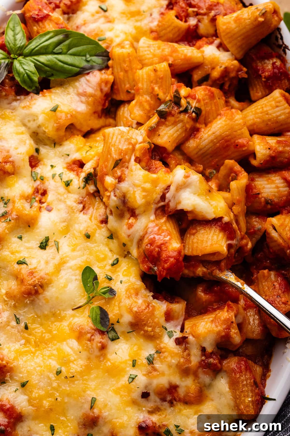 Baked Ziti Without Ricotta: Creamy Oven-Baked Pasta Recipe 7 A close up of a spoon in cheesy baked ziti.
