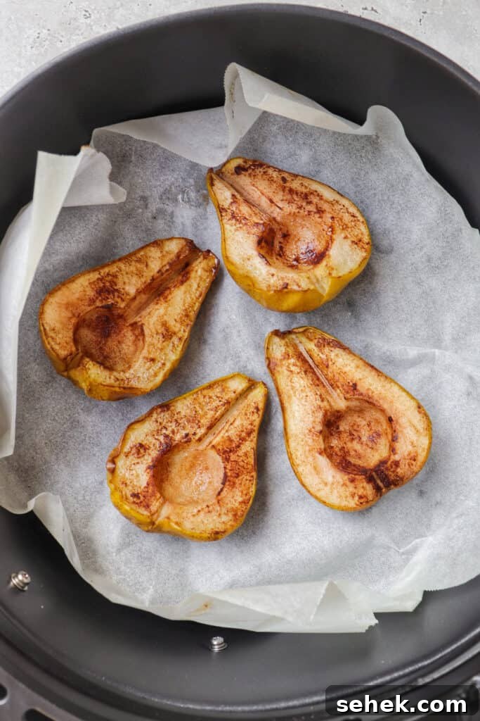 Crispy Cinnamon Air Fryer Pears with Honey Glaze 6 Roasted cinnamon pears in air fryer basket.