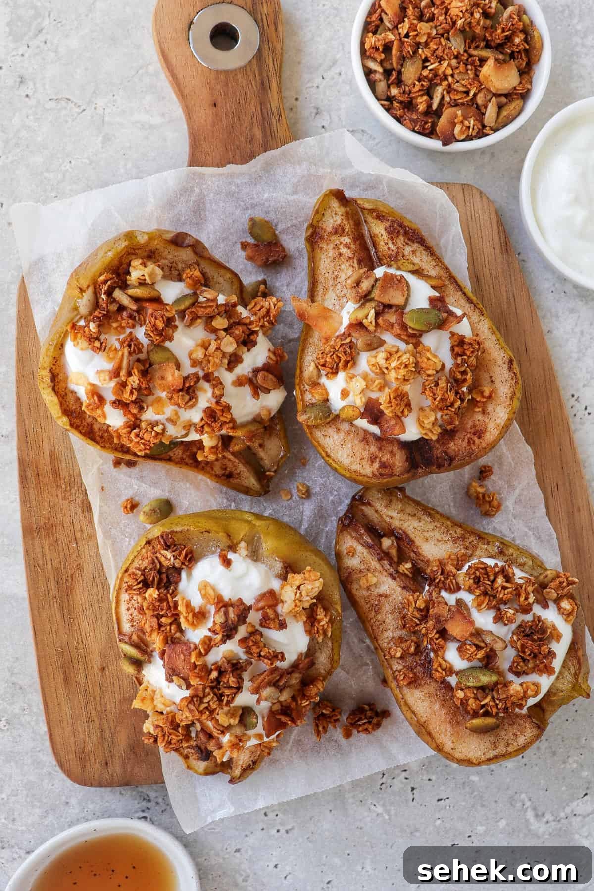 Crispy Cinnamon Air Fryer Pears with Honey Glaze 8 close up shot of baked pears on wooden board topped with plain yoghurt and granola.