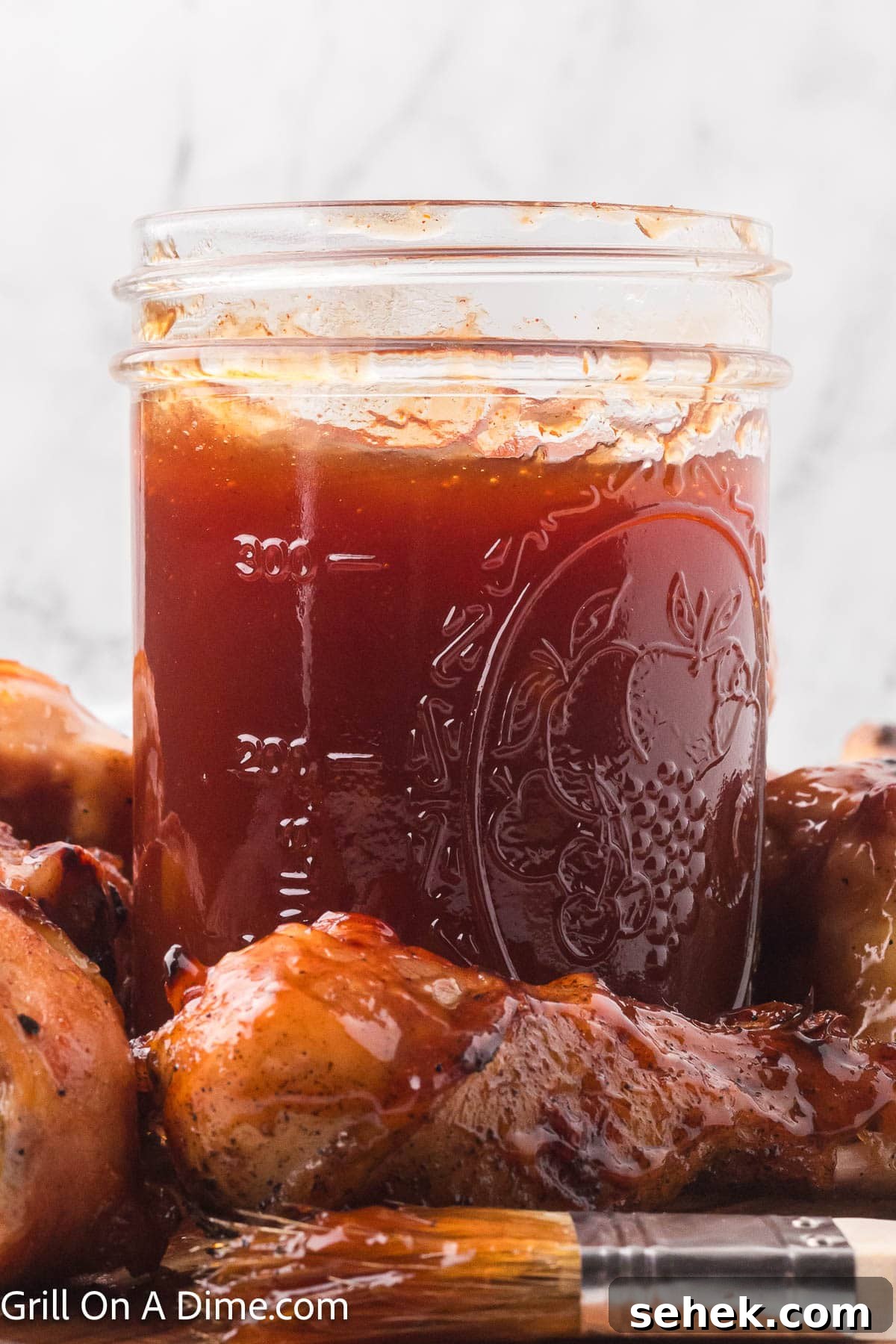 Peach BBQ Sauce Recipe for Grilling and Glazing 2 Peach BBQ Sauce in a clear mason jar with the sauce basted on grilled meat around the jar