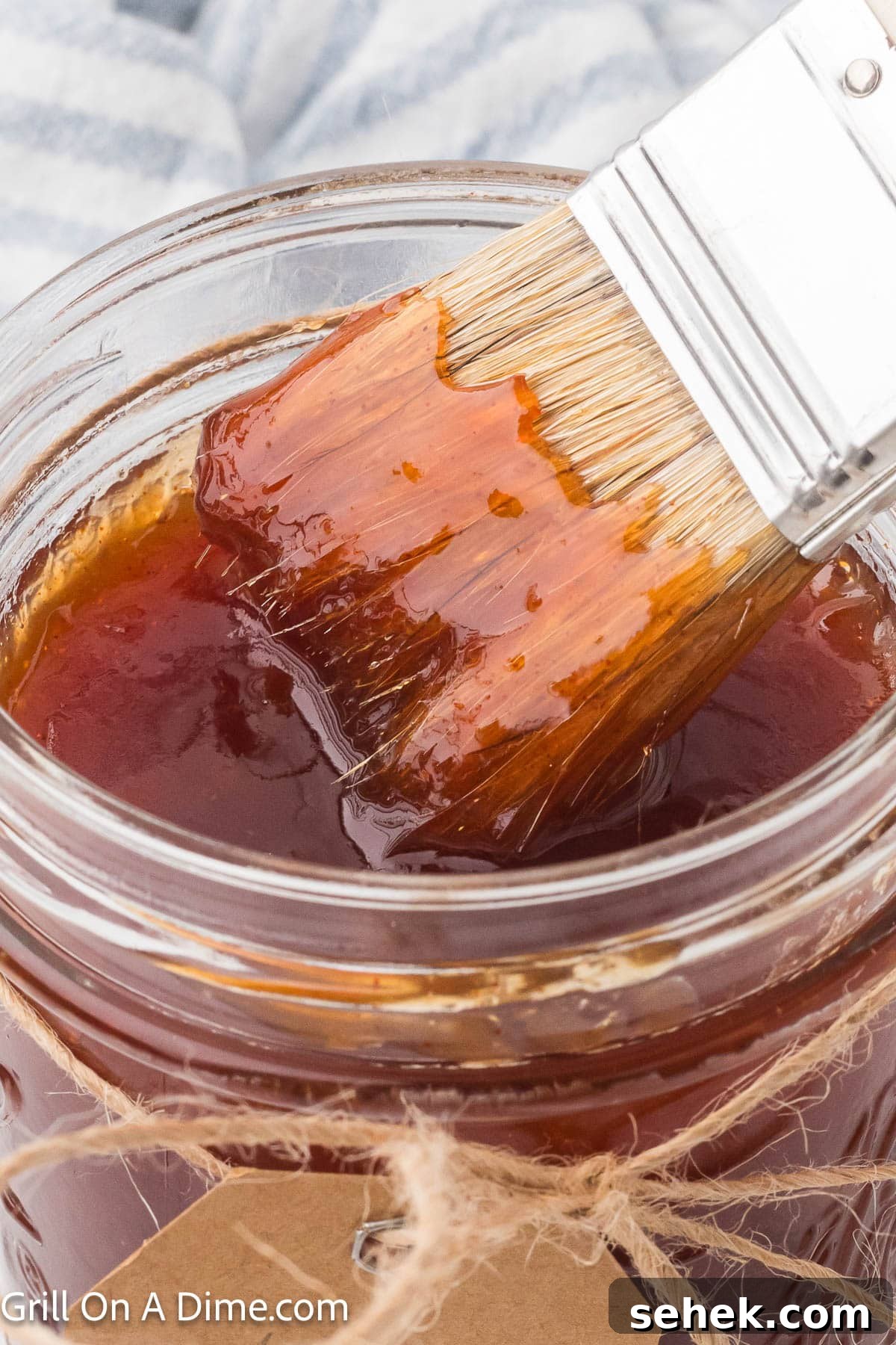 Peach BBQ Sauce Recipe for Grilling and Glazing 5 Peach BBQ Sauce in a clear mason jar with a serving on a basting brush