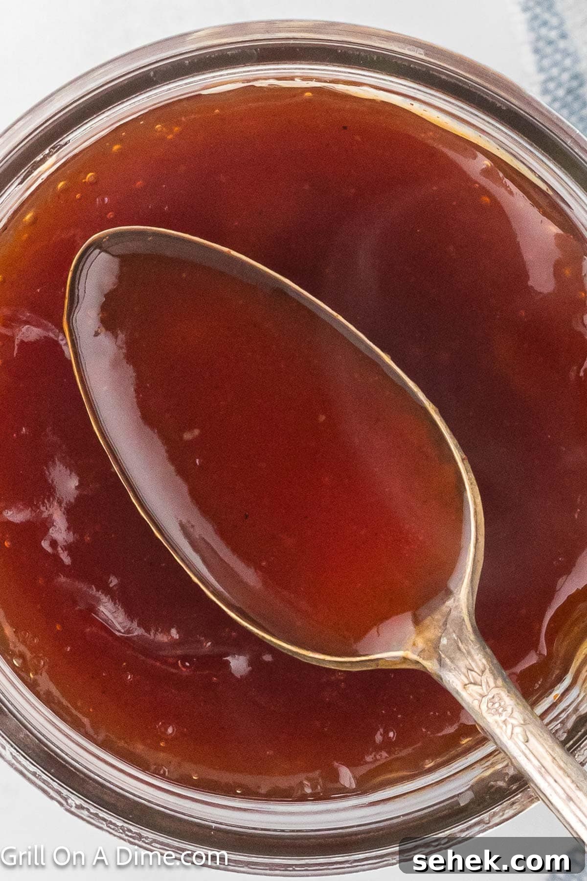 Peach BBQ Sauce Recipe for Grilling and Glazing 6 Peach BBQ Sauce in a mason jar with a serving on a spoon