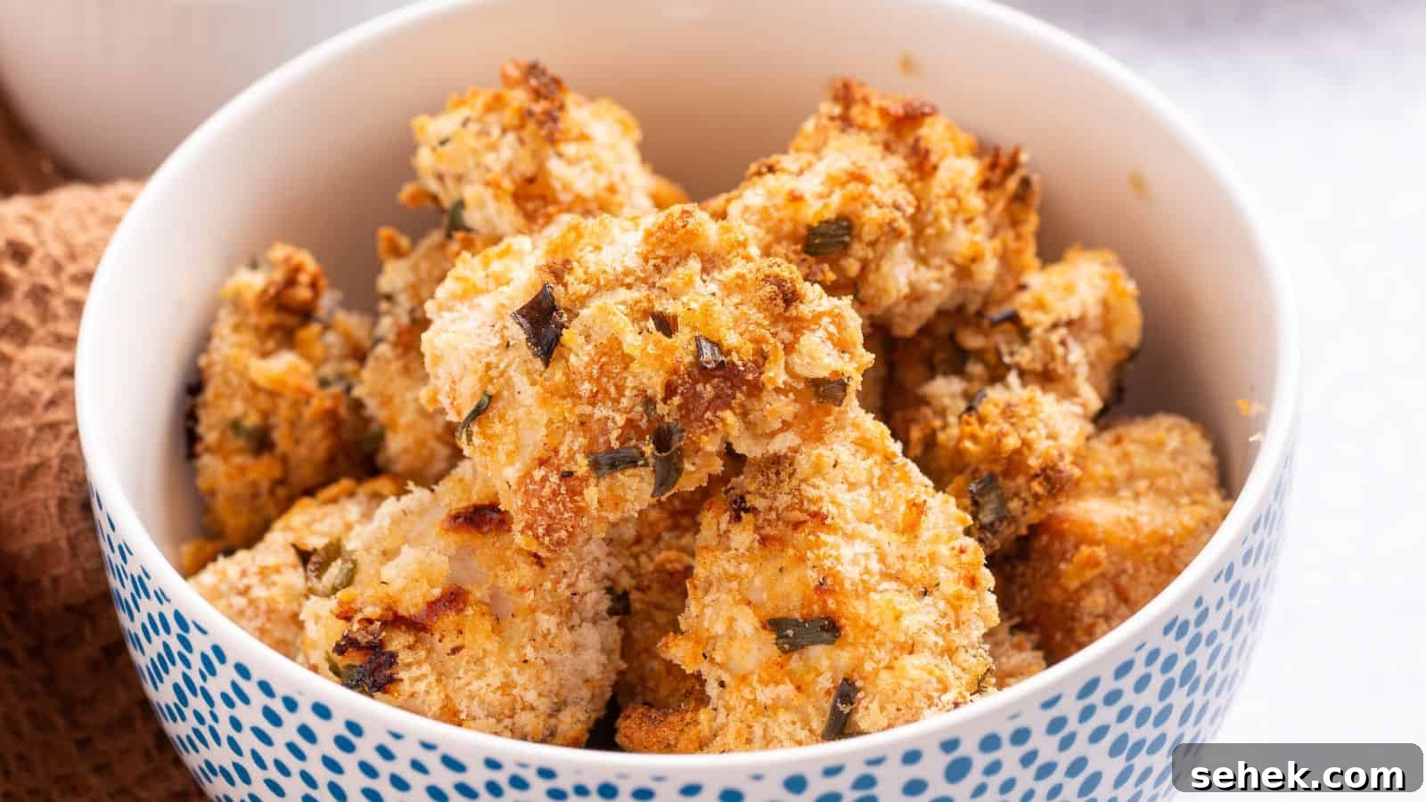 A bowl of golden brown popcorn chicken on a table.