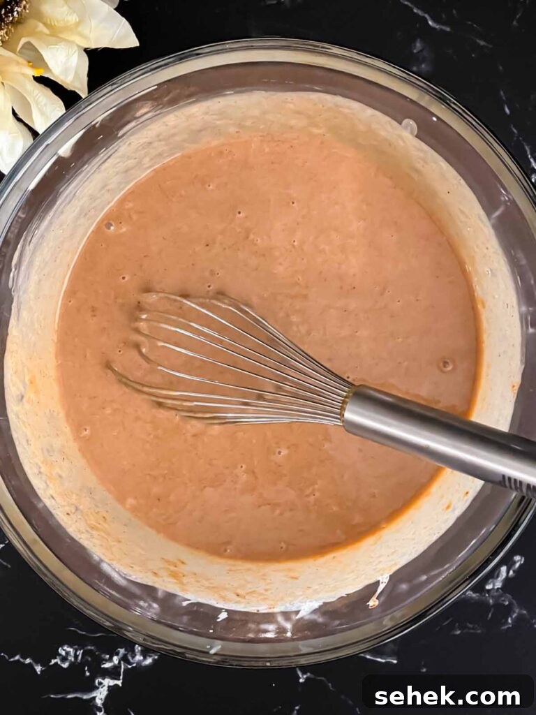 Irresistible Apple Butter Pie Recipe for Fall Baking 6 Apple butter pie mixture whisked together in a glass bowl.