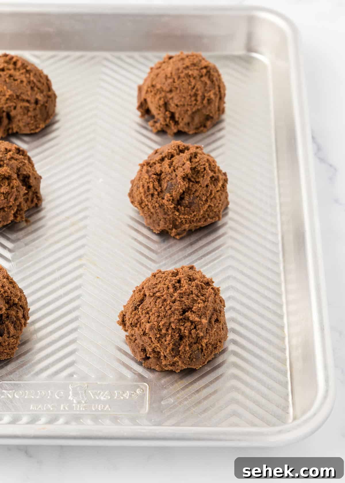 Ultimate Double Chocolate Cookies Recipe for Rich, Fudgy Results 6 Double chocolate chip dough balls on a baking sheet.