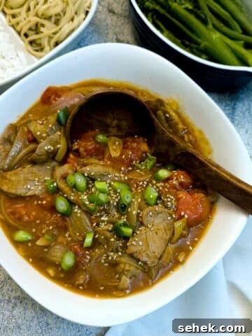 Cantonese-style pork and tomato stir-fry in a white dish.