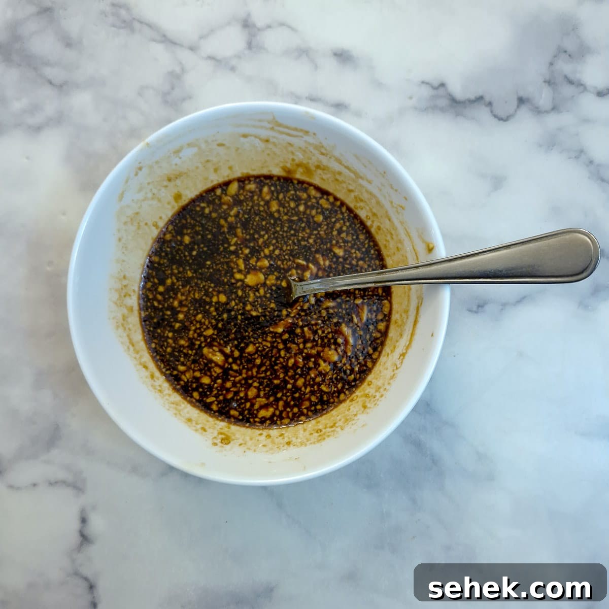 A small white dish of maple syrup glaze.