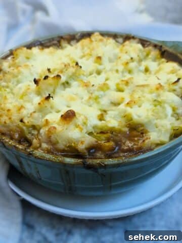 Colcannon-topped sausage bake in a green casserole dish.