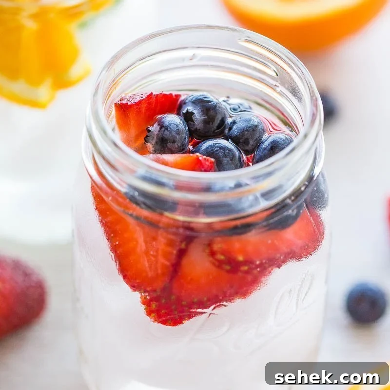 Fresh strawberries and blueberries in a glass jar.