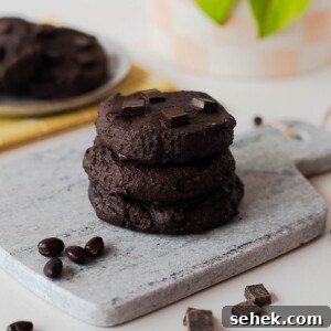 Fudgy Flourless Black Bean Cookies — Vegan Chocolate Treats 11 Stack of fudgy chocolate black bean cookies on a stone board with chocolate pieces