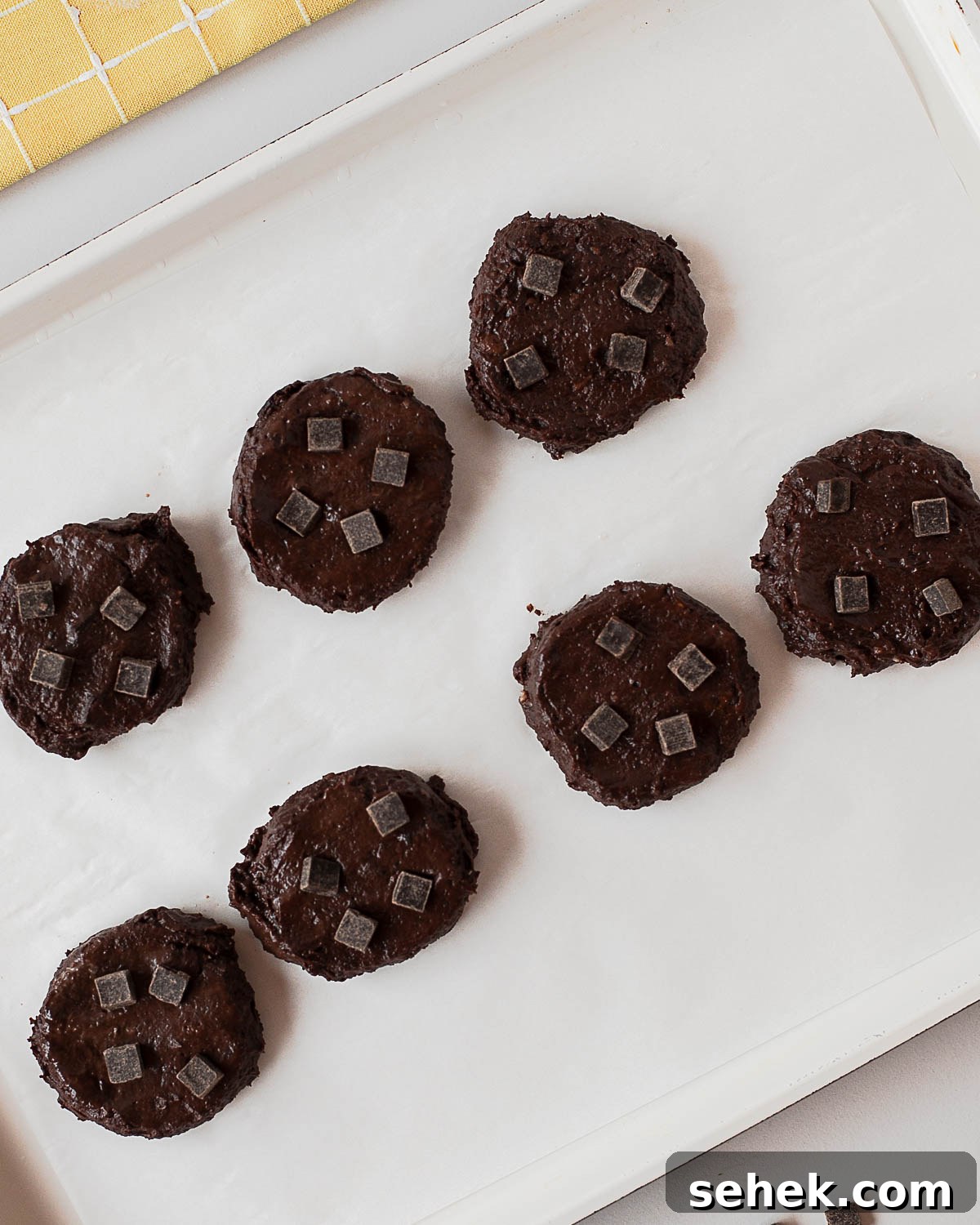 Fudgy Flourless Black Bean Cookies — Vegan Chocolate Treats 7 Scooped black bean cookie dough portions on parchment-lined baking sheet with chocolate chunks
