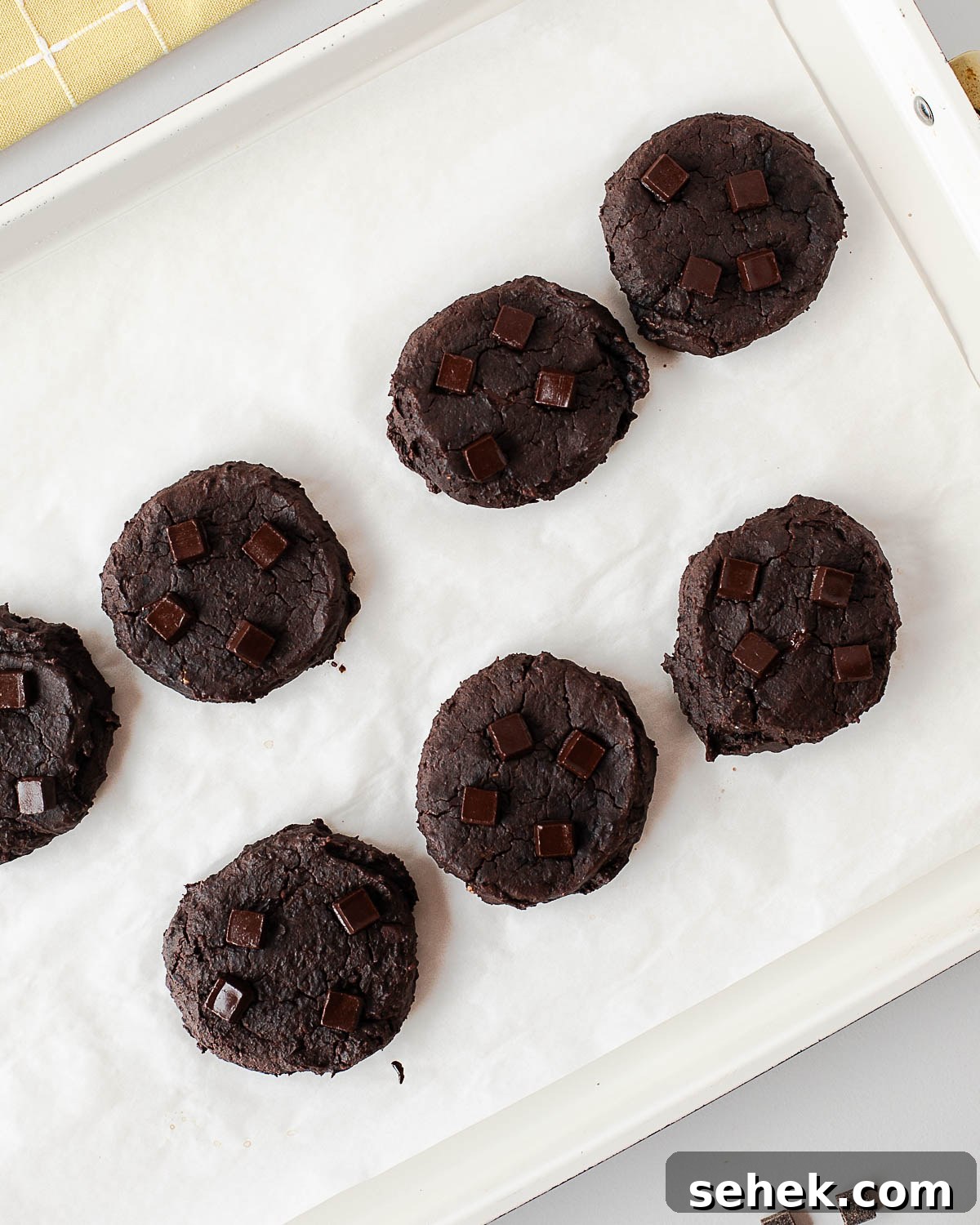 Fudgy Flourless Black Bean Cookies — Vegan Chocolate Treats 8 Baked black bean cookies with dark chocolate chunks on a baking tray