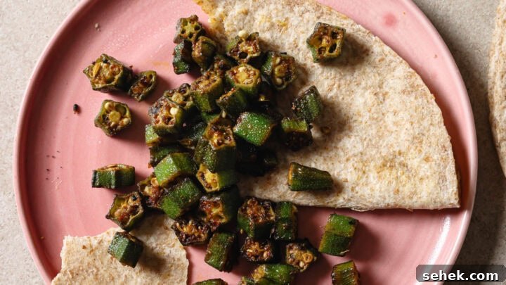 Partially eaten plate of Bhindi Fry with roti.