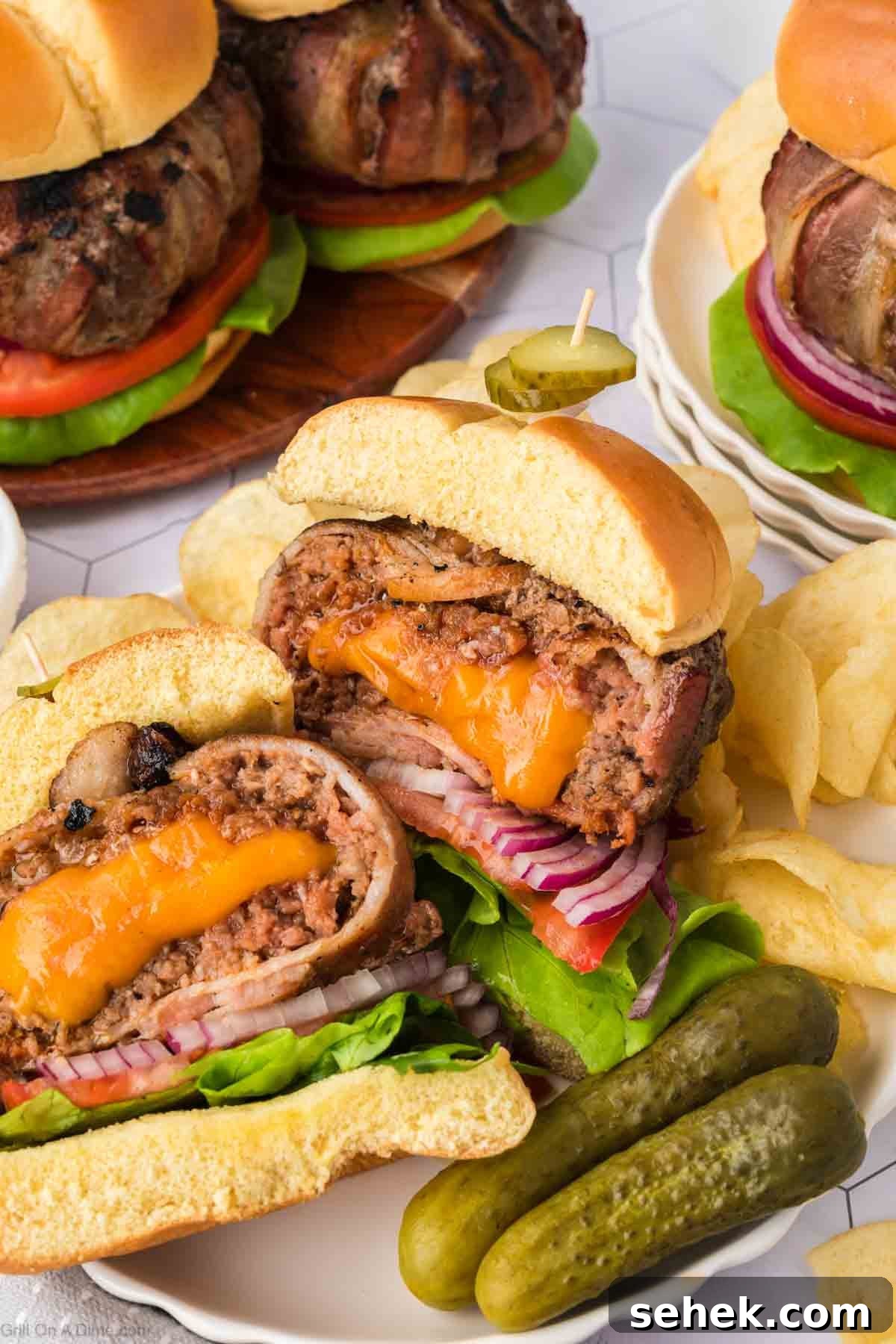 Bacon-Wrapped Burger Recipe: Juicy Grilled Bacon Burger Guide 12 Bacon wrapped burger cut in half with melty cheese in the center of the burger on a plate with pickles and potato chips
