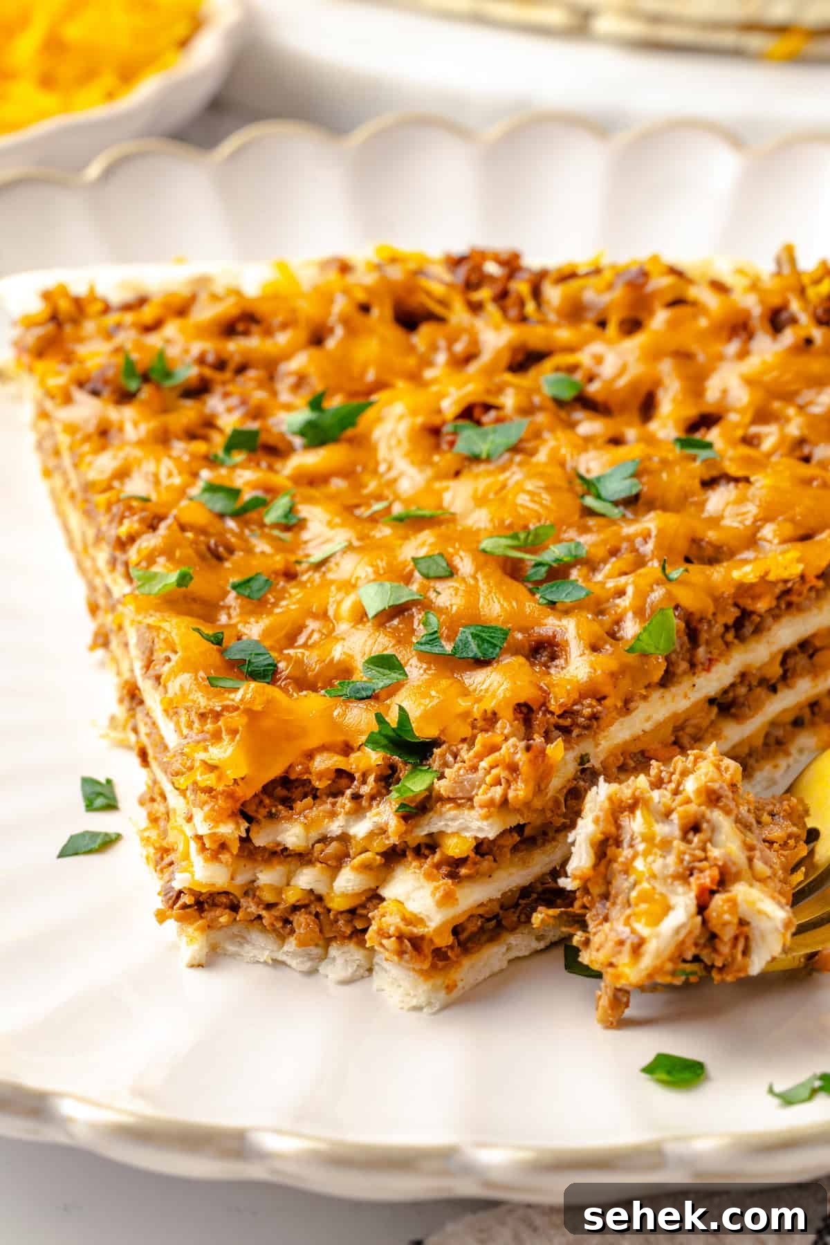 Slice of taco bake on plate with tip on fork