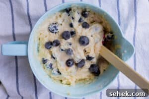 Lemon-Infused Blueberry Muffins Recipe 11 blueberrys being mixed into batter