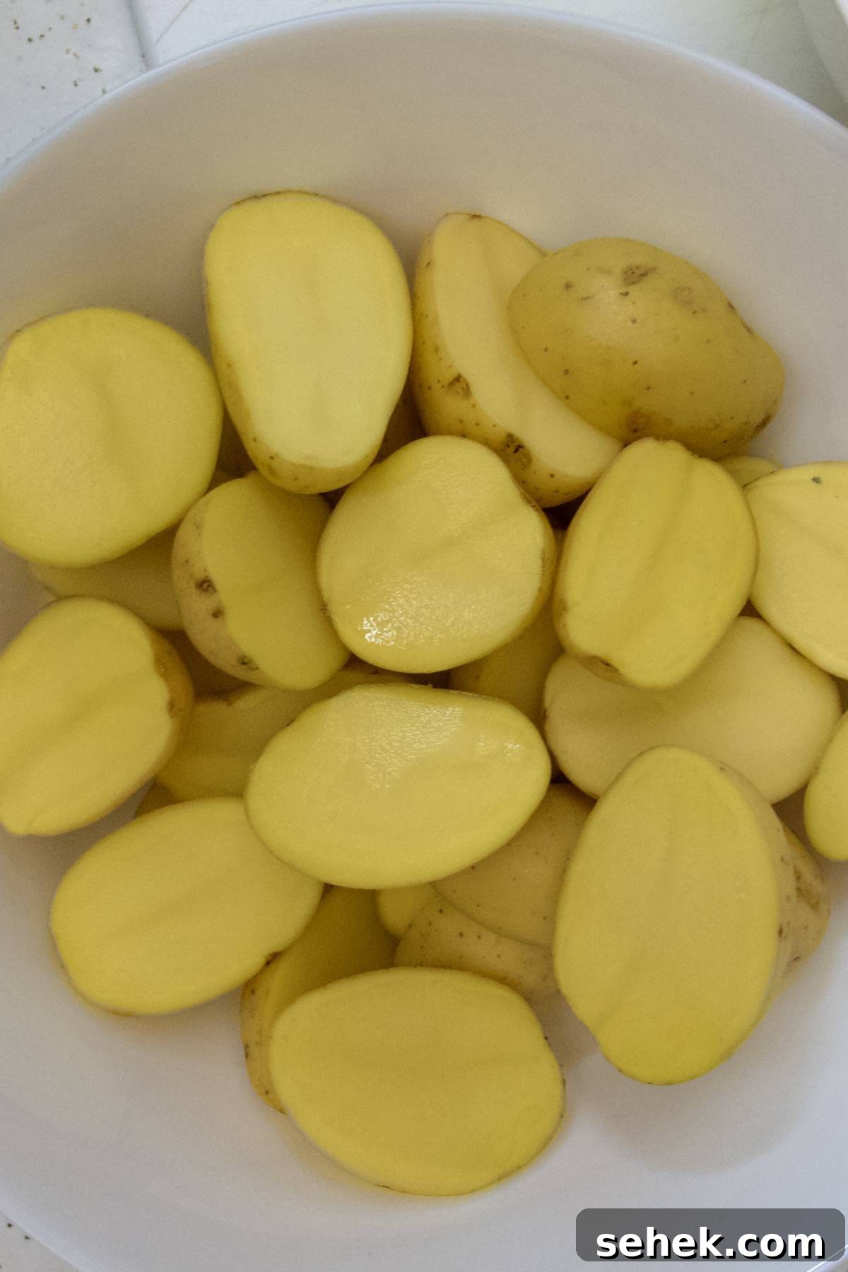 Crispy Parmesan Roasted Potatoes with Garlic and Herbs 4 Yukon gold potatoes cut in half in a bowl