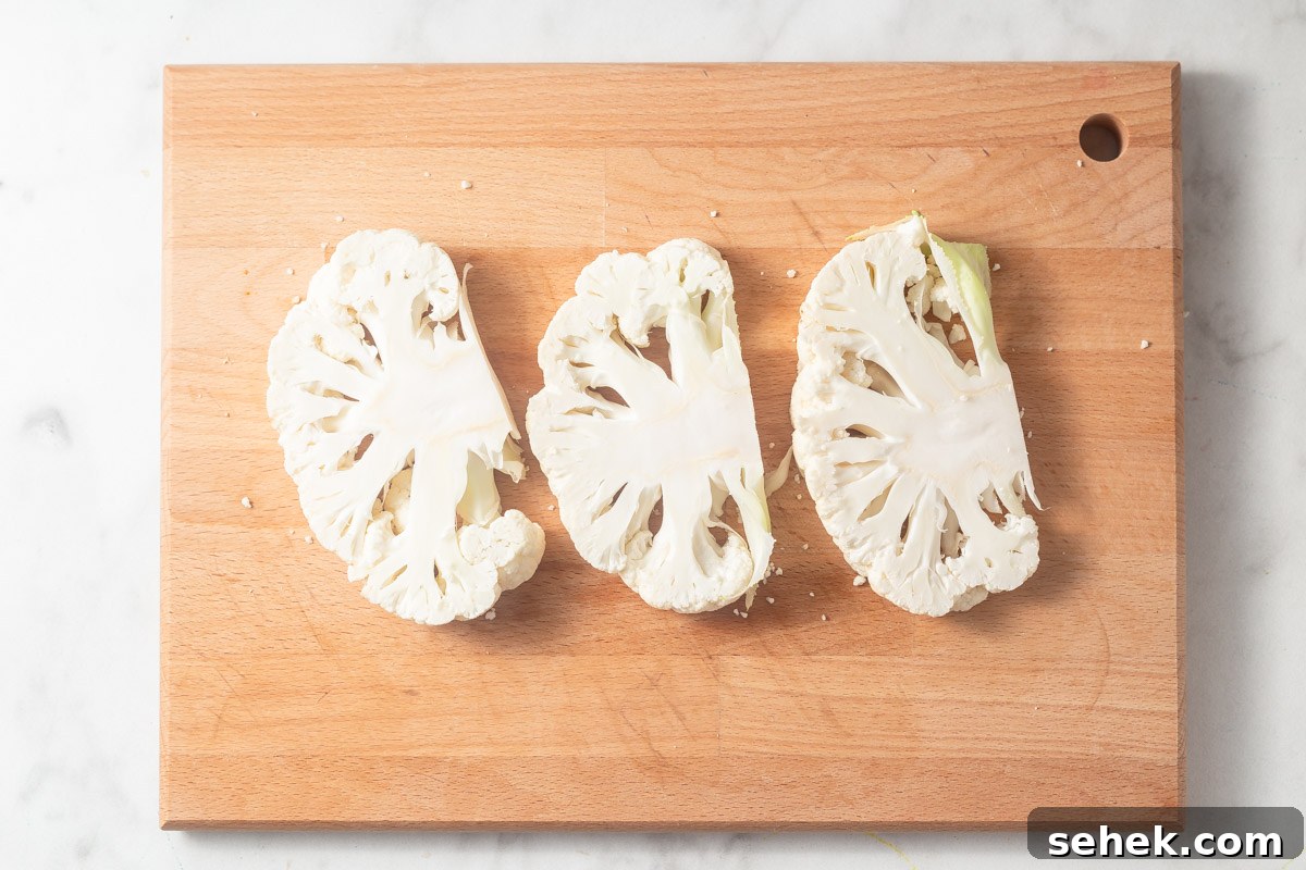 Crispy Air Fryer Cauliflower Steaks with Garlic Herb Sauce 7 cauliflower steaks on the cutting board.