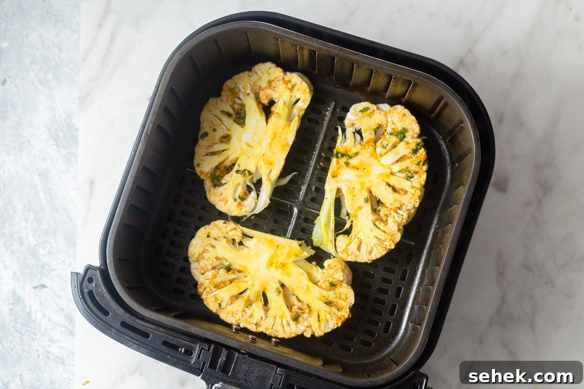 Crispy Air Fryer Cauliflower Steaks with Garlic Herb Sauce 10 cauliflower steaks in the air fryer basket.