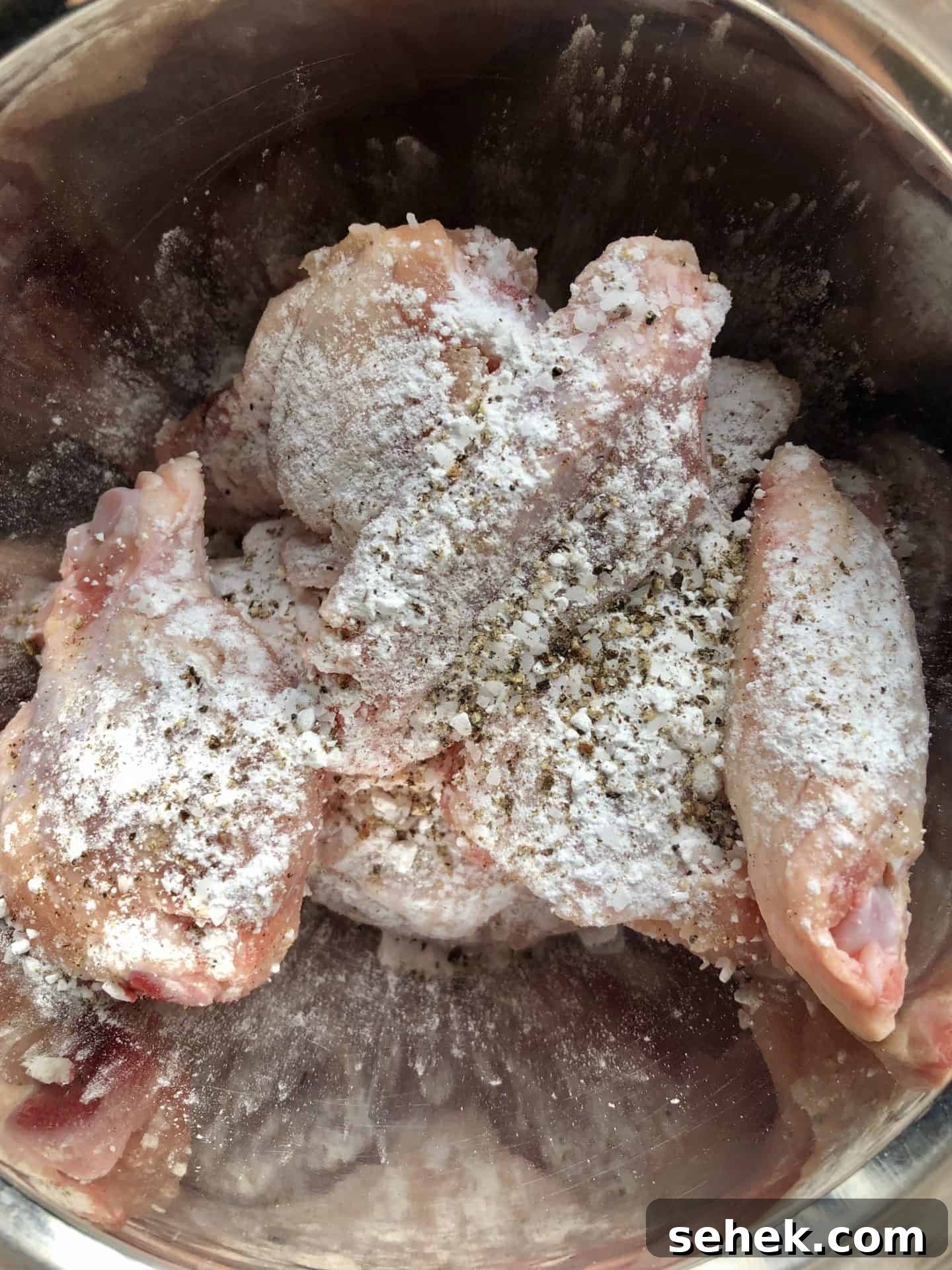 Crispy Air Fryer Wings for Game Day 7 Chicken wings in bowl topped with baking powder overhead shot