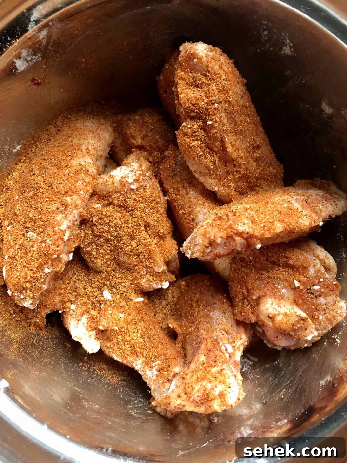 Crispy Air Fryer Wings for Game Day 8 Chicken wings in bowl topped with dry rub overhead shot