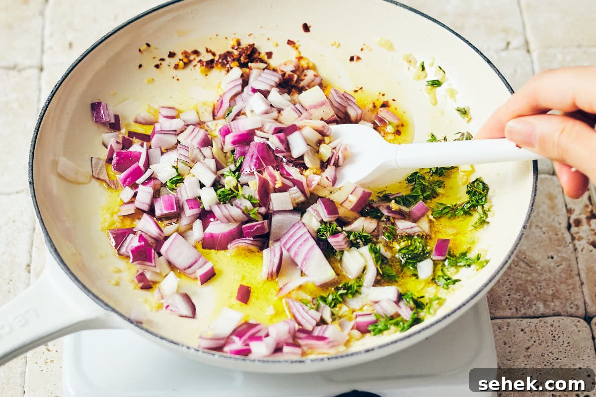 Tuscan Bean Salad with Tomatoes, Olives & Fresh Herbs 4 Sauteeing red onion, garlic, chili flakes in olive oil in a skillet for bean salad.