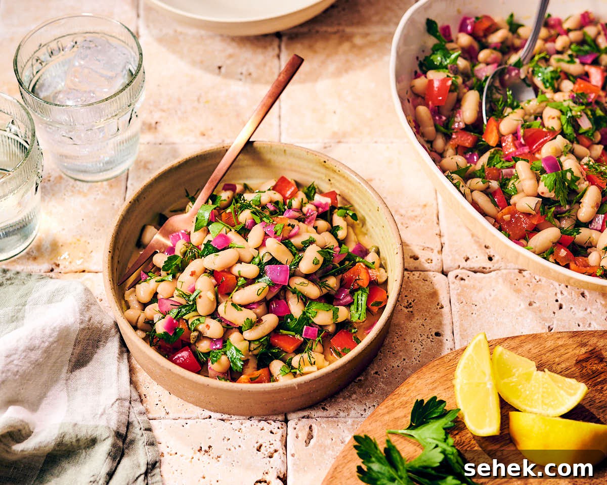 Tuscan Bean Salad with Tomatoes, Olives & Fresh Herbs 8 Two bowls of Italian Bean Salad with lemon wedges and parsley.