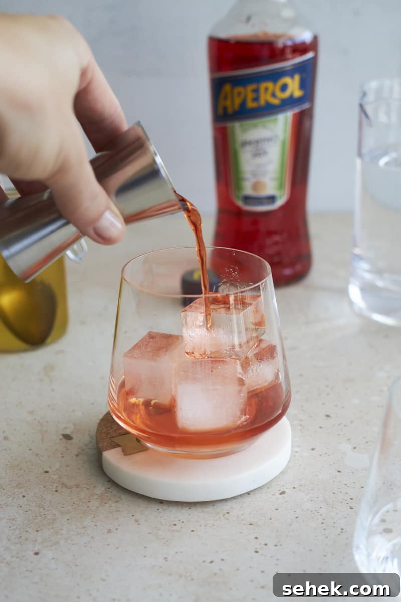 Aperol Soda Cocktail Recipe: Refreshing Italian Spritz Alternative 6 Aperol being poured into the cocktail glass.