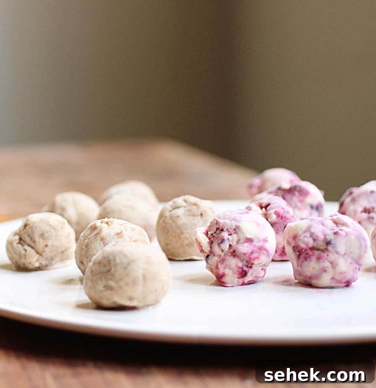 Ice Cream–Filled Granola Truffles: No-Bake Dessert Bites 4 White plate on wooden table with small ice cream balls.