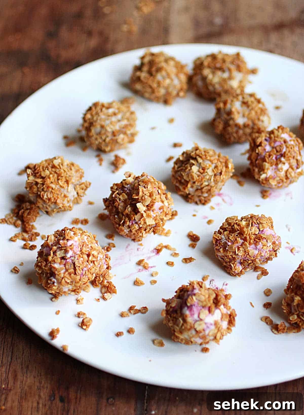 Ice Cream–Filled Granola Truffles: No-Bake Dessert Bites 6 Small ice cream truffles covered in granola on white plate