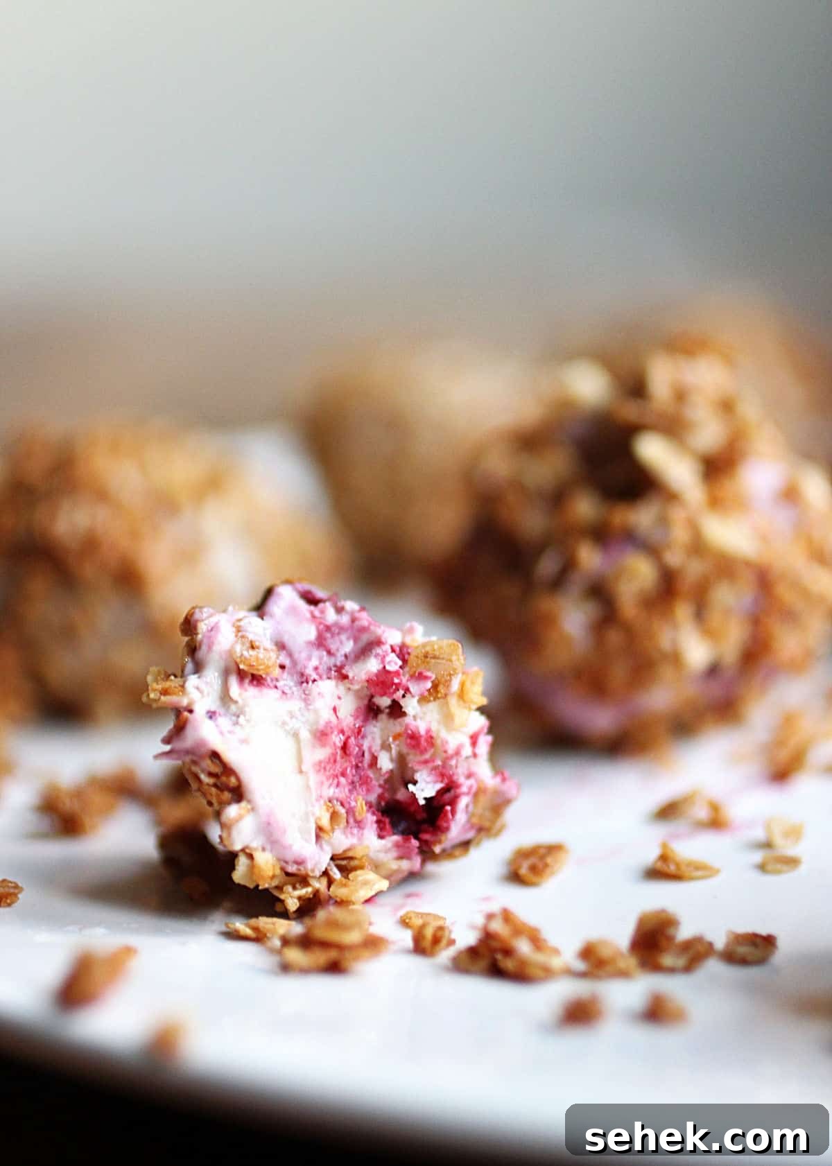 Ice Cream–Filled Granola Truffles: No-Bake Dessert Bites 7 Bitten ice cream granola truffle and others whole on white plate