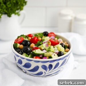 Classic Greek Cucumber Salad with Feta and Olives 12 Vegan Mediterranean cucumber salad in a blue and white bowl including onion, tomatoes, olives, cucumber, chickpeas, and herbs