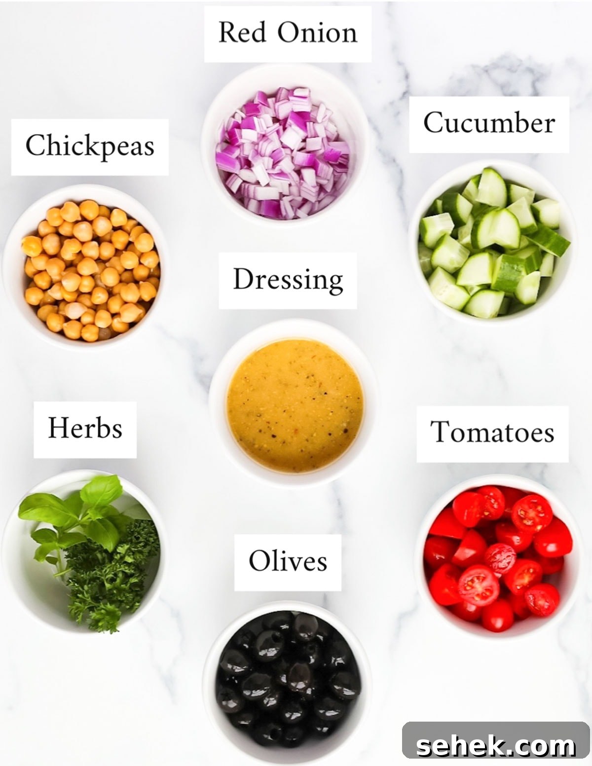 Classic Greek Cucumber Salad with Feta and Olives 3 Labeled ingredients including: red onion, chickpeas, cucumber, dressing, herbs, olives, and tomatoes