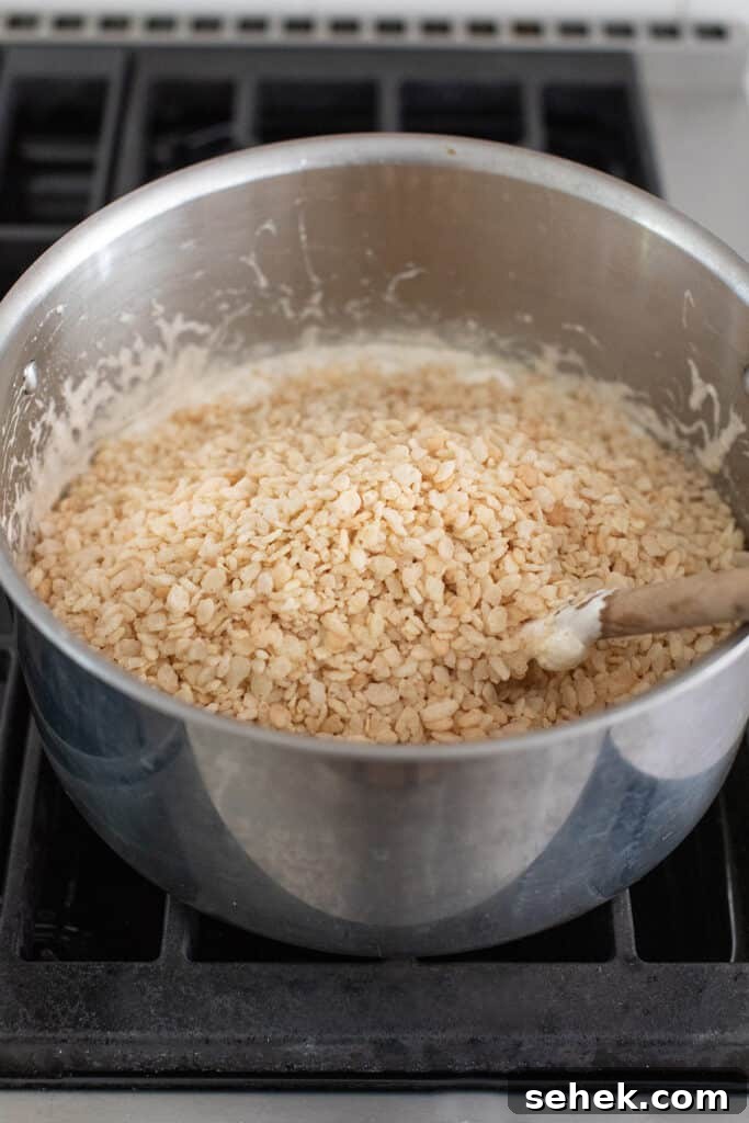 stirring rice krispies to the pot