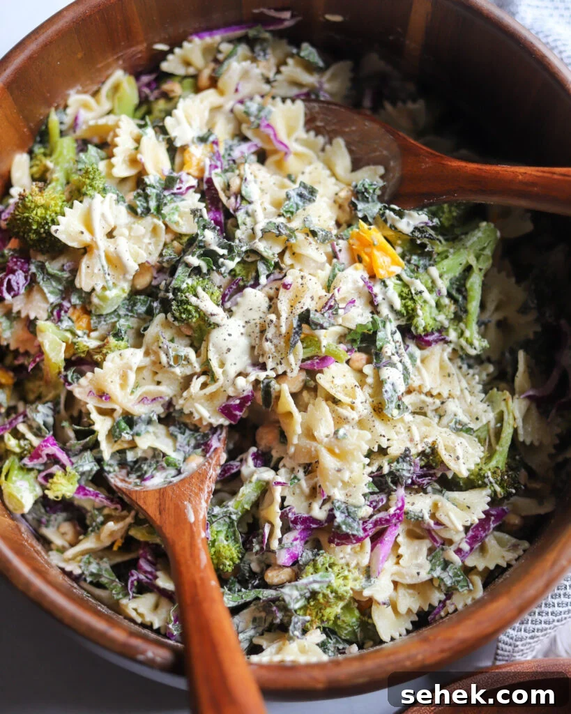 vegan caesar pasta salad with kale in a wooden serving bowl.
