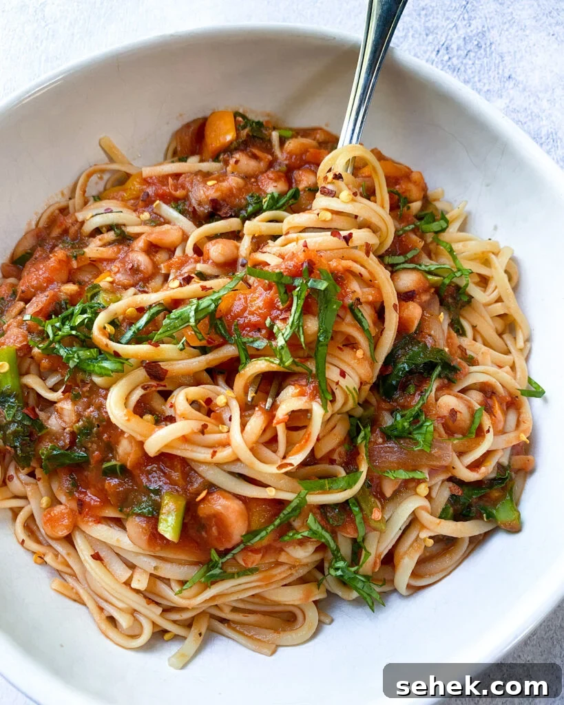 white bean and kale linguine in a white bowl.