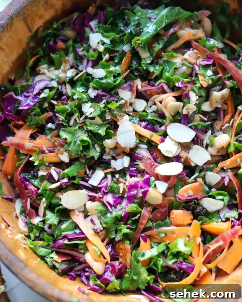 the best kale crunch salad with almonds and carrots in a wooden serving bowl.