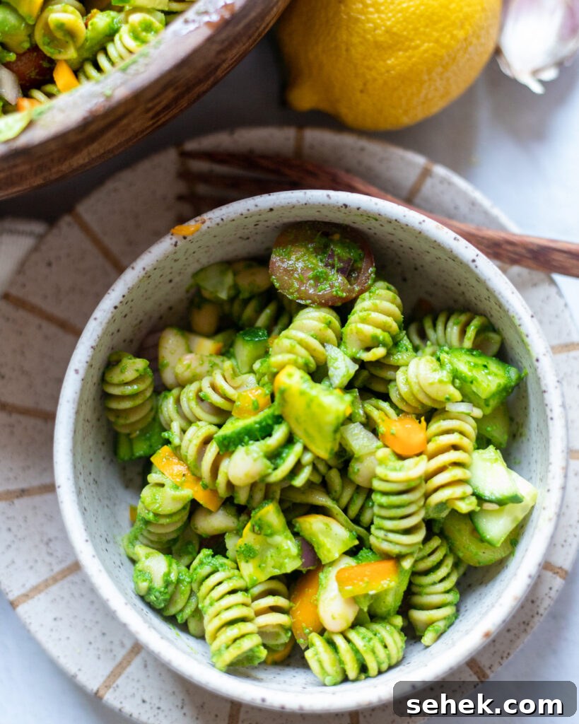 image kale pesto pasta salad in a ceramic bowl.