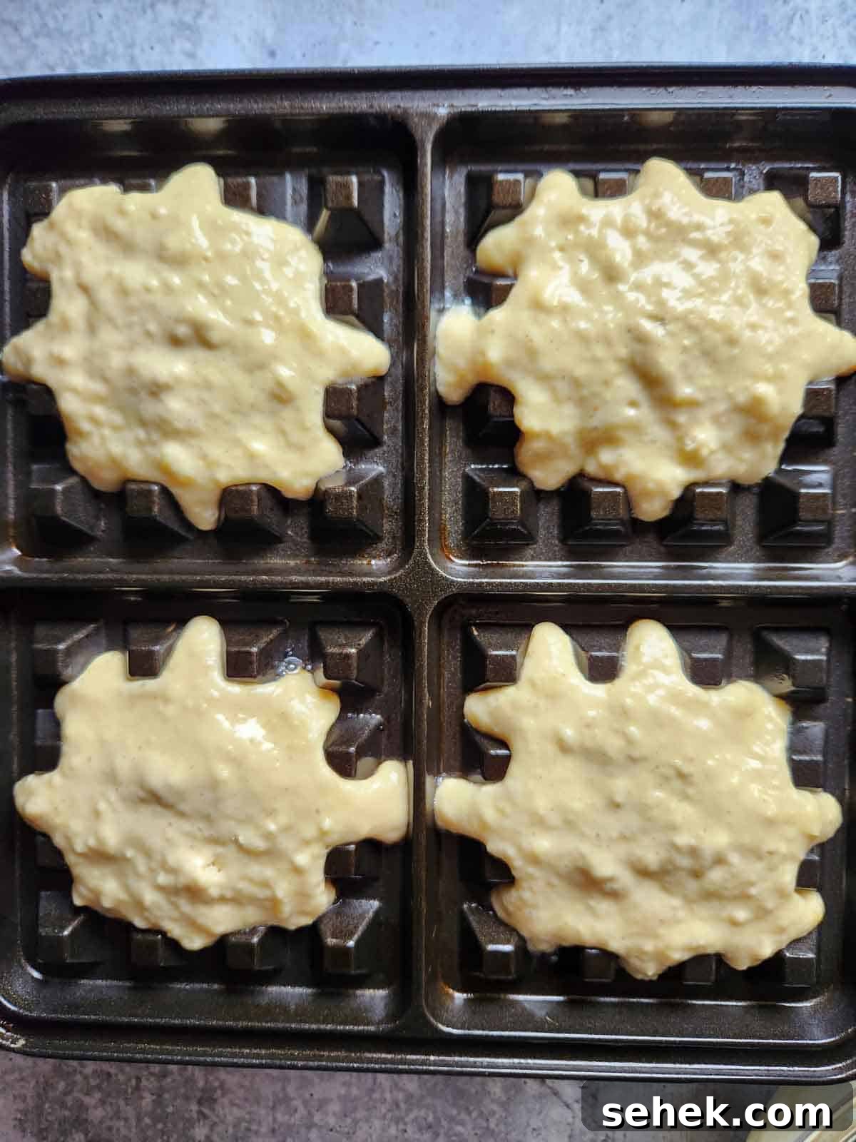 Spiced Eggnog Waffles with Warm Holiday Flavors 8 Batter placed on a waffle iron.