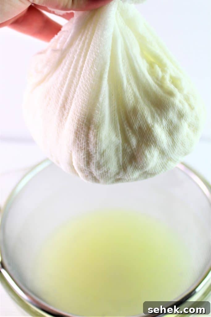 How to Make Creamy Homemade Ricotta Cheese in 30 Minutes 3 draining ricotta cheese in cheesecloth over sieve and bowl