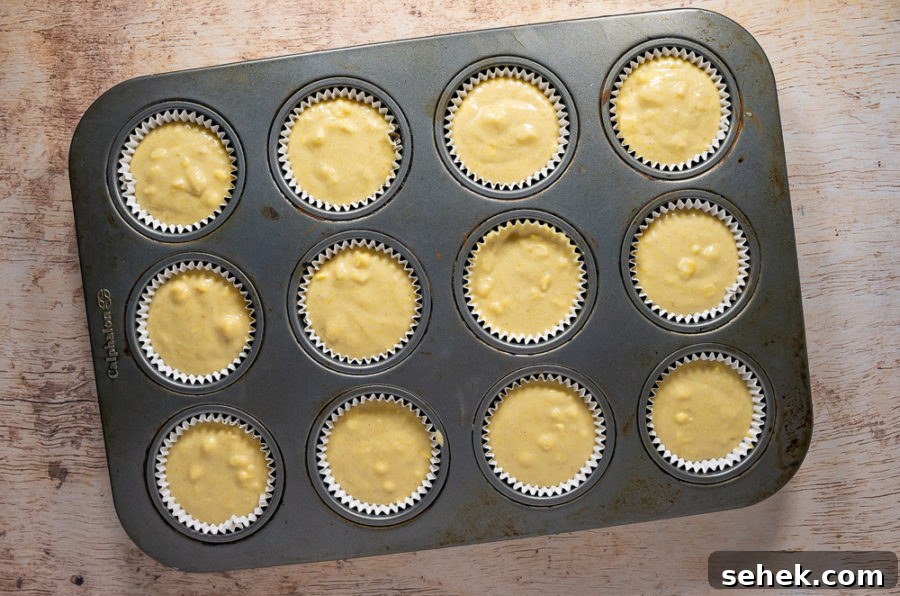 Classic Cornbread Muffins Made with Whole Kernel Corn 6 Muffin pan filled with cornbread batter