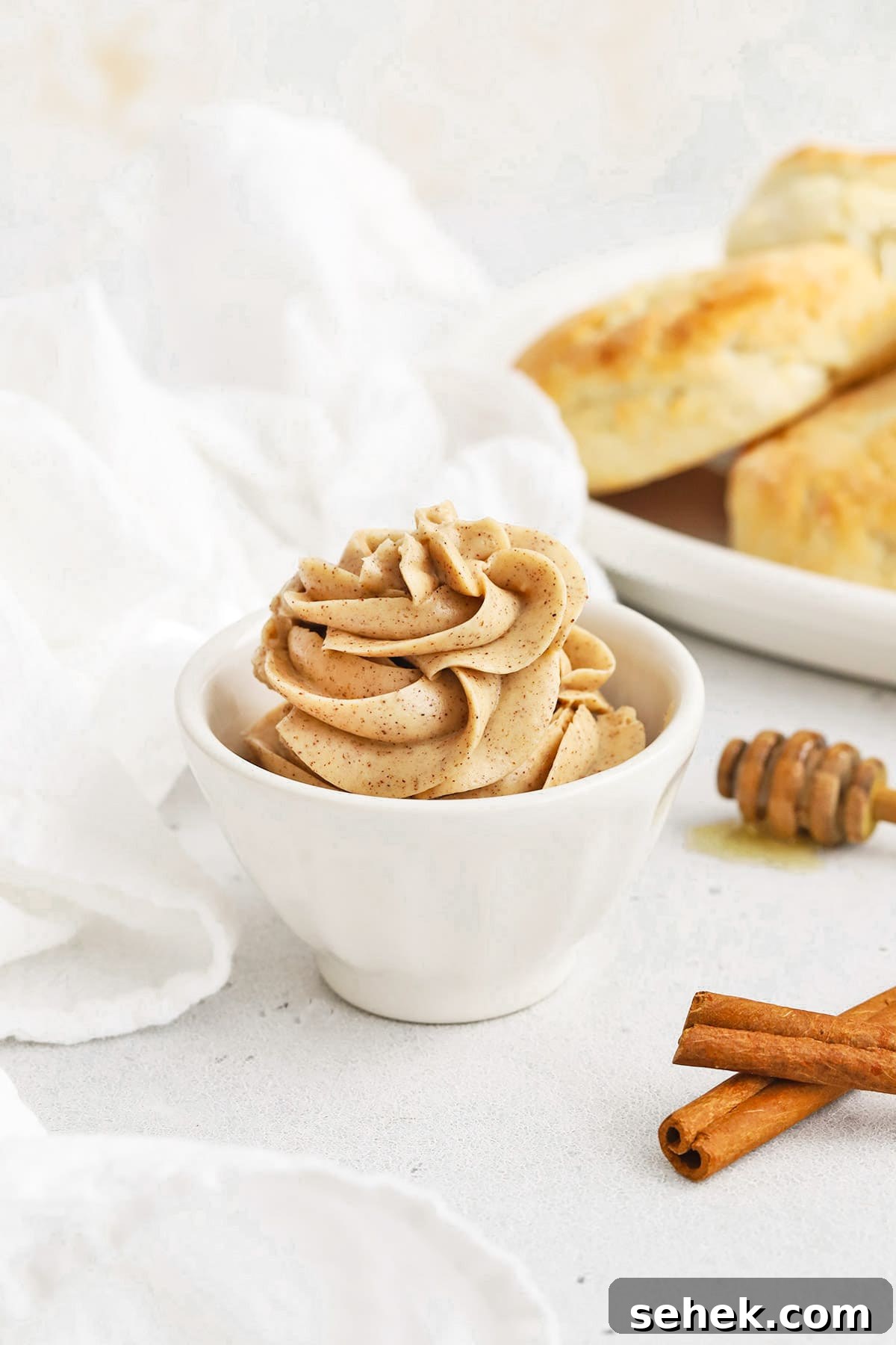 Whipped Honey Butter with Cinnamon — Fluffy Spread Recipe 15 Front view of Whipped Cinnamon Butter Piped into a small white bowl in a pretty design