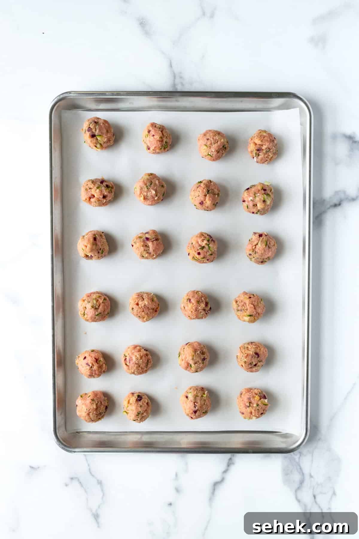 Baked Turkey Meatballs with Zucchini on a baking sheet ready to bake.