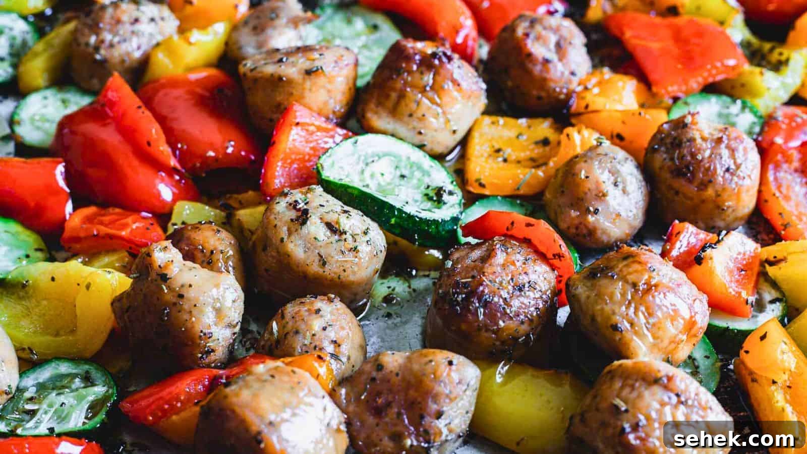 15 Quick Weeknight Dinners to Save You Time and Stress 11 Close-up of roasted meatballs with a mix of colorful, chopped bell peppers and zucchini slices.