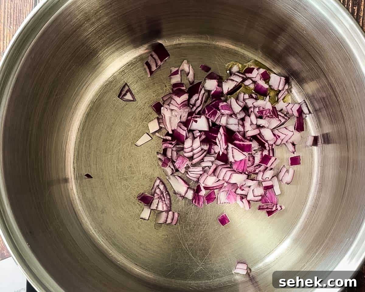 Smoked Brisket and Bean Chili Recipe for Flavorful Comfort 5 Diced red onion sautéing in olive oil in a large pot.