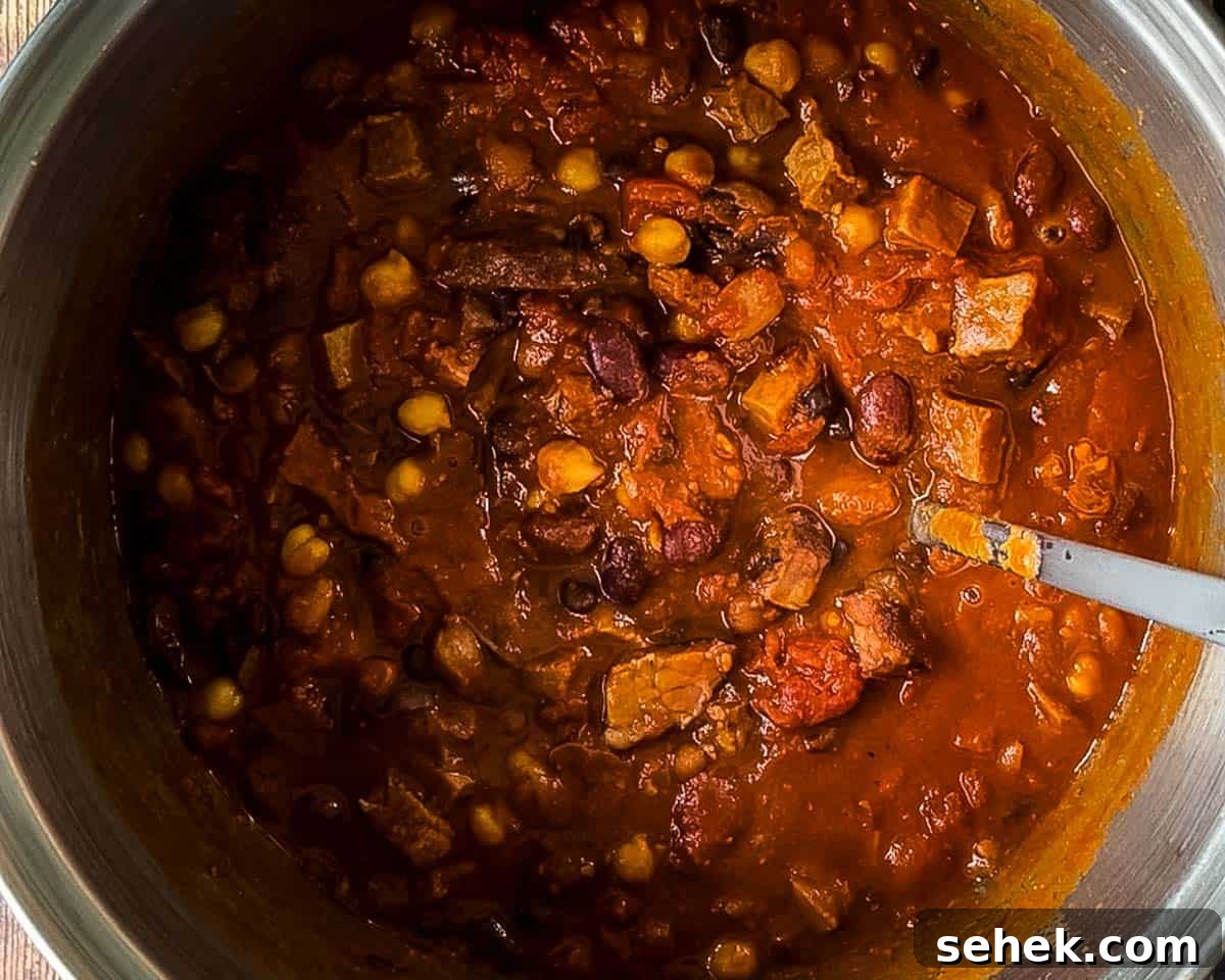 Smoked Brisket and Bean Chili Recipe for Flavorful Comfort 7 Thick smoked brisket chili in a pot with mixed beans, tomatoes, and chunks of smoked beef brisket.