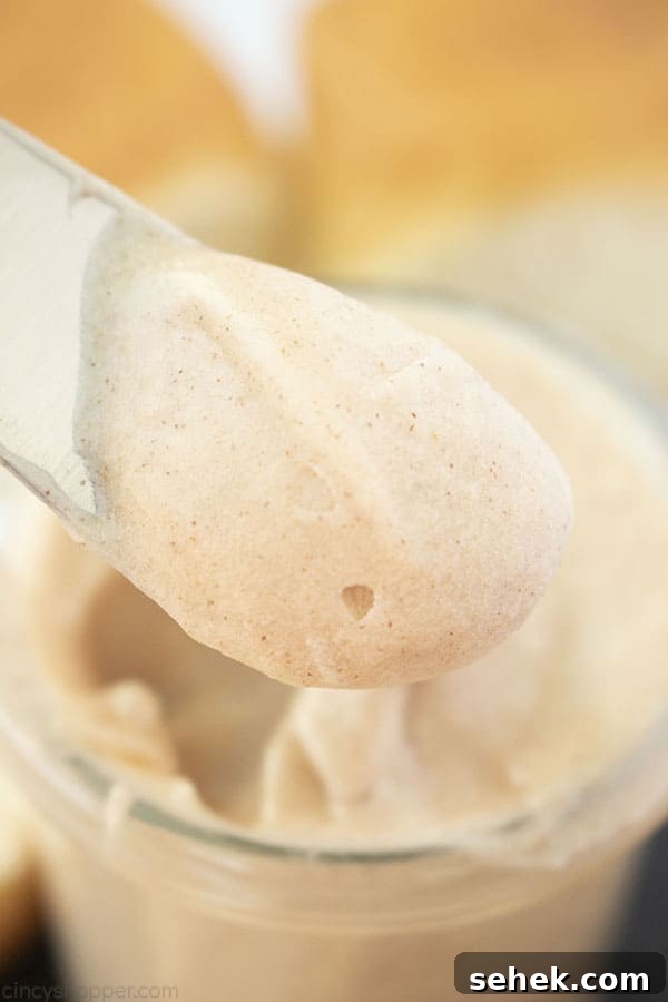 Homemade Cinnamon Butter Recipe for Toasts and Pastries 3 Texas Roadhouse Copycat Cinnamon Butter on a knife with jar and rolls in the background