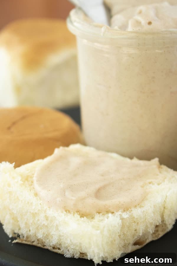 Homemade Cinnamon Butter Recipe for Toasts and Pastries 5 Cinnamon Butter spread on a roll. Jar and rolls in the background