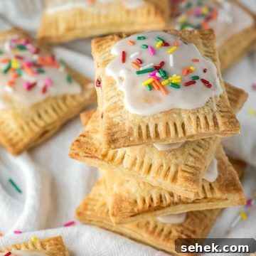 4 stacked strawberry pop tarts on dish towel with more in background